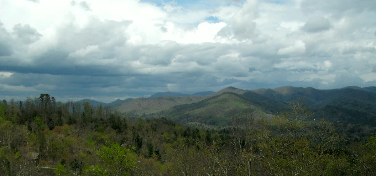 Clouds above a wooded mountain landscape at Long Branch Estates