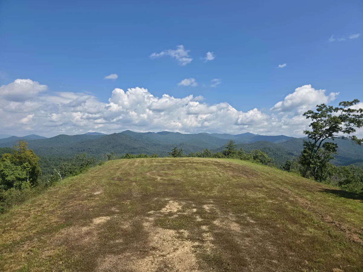Grassy clearing and wooded mountain ridges in the first supplied Lot 6 photo set